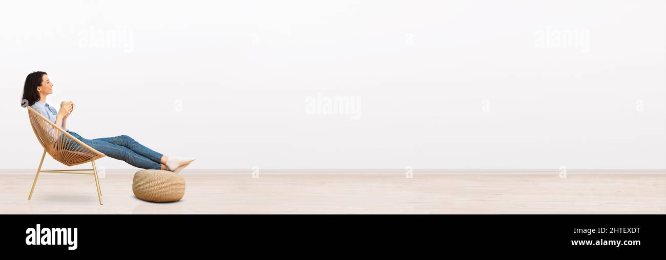 Entspannte tausendjährige Frau, die zu Hause chillt und Kaffee trinkt Stockfoto