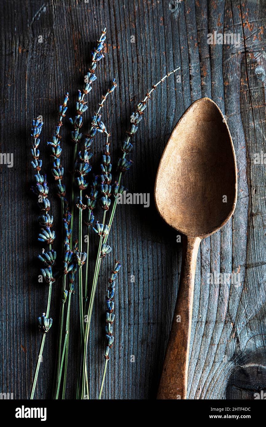 Alter Holzlöffel mit getrocknetem Lavendel auf rustikalem Holzhintergrund Stockfoto