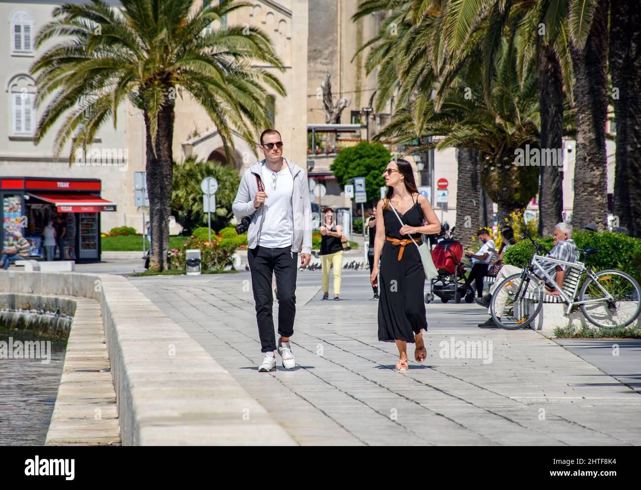 Ein junges Paar Touristen, die auf der Strandpromenade in Split, Kroatien, spazieren gehen Stockfoto