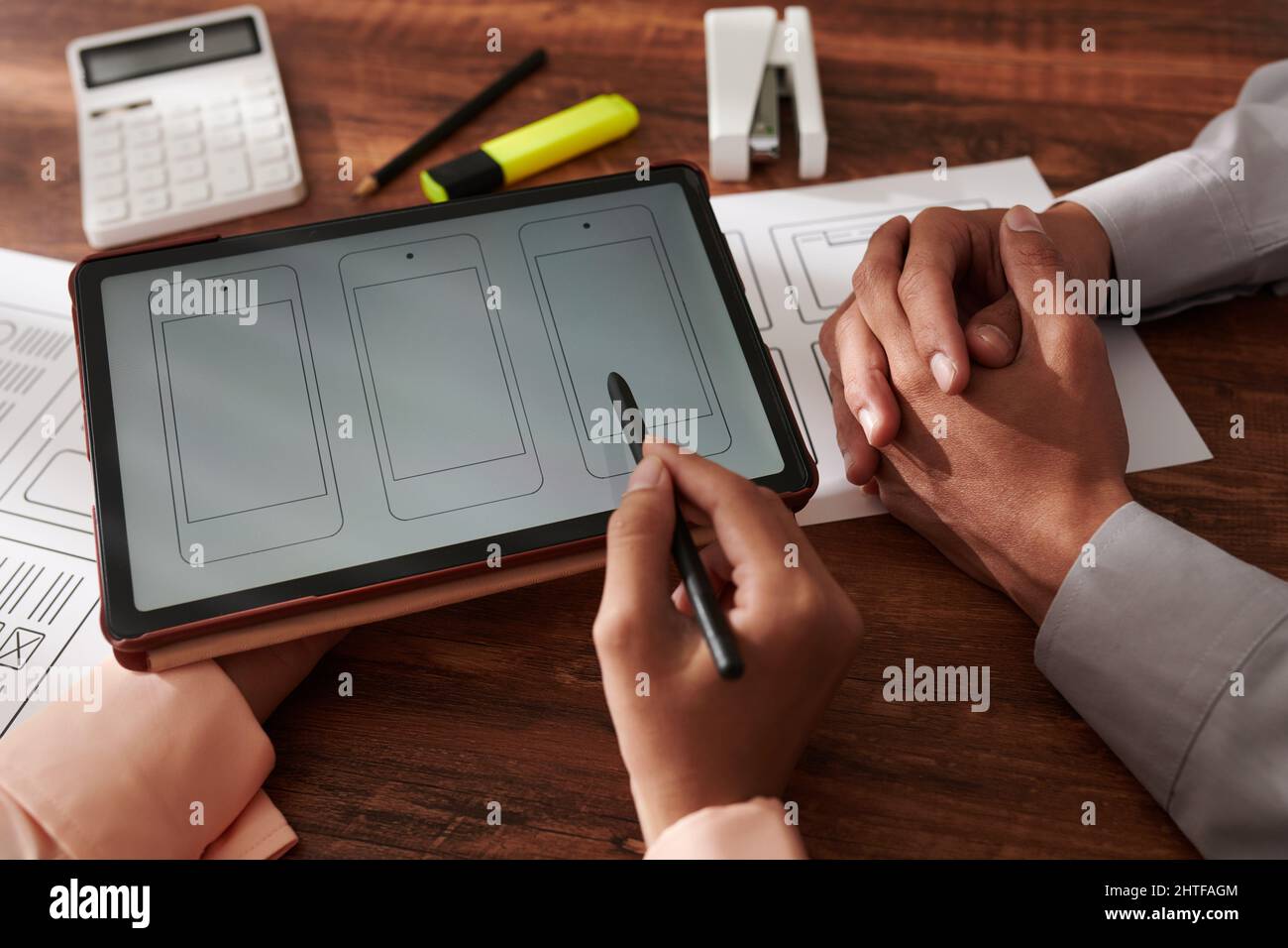 Projektmanager und UI-Designer diskutieren Schnittstelle der neuen mobilen Anwendung bei der Besprechung Stockfoto