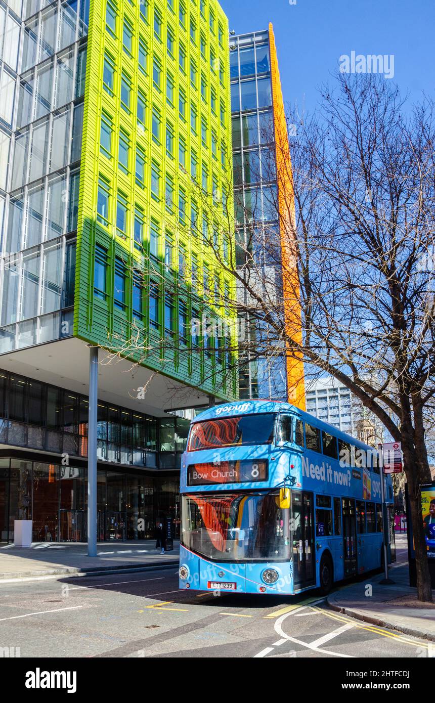 Ein blauer Bus, der an einer Bushaltestelle vor den modernen Bürogebäuden im Central Saint Giles-Viertel in London, Großbritannien, geparkt ist Stockfoto