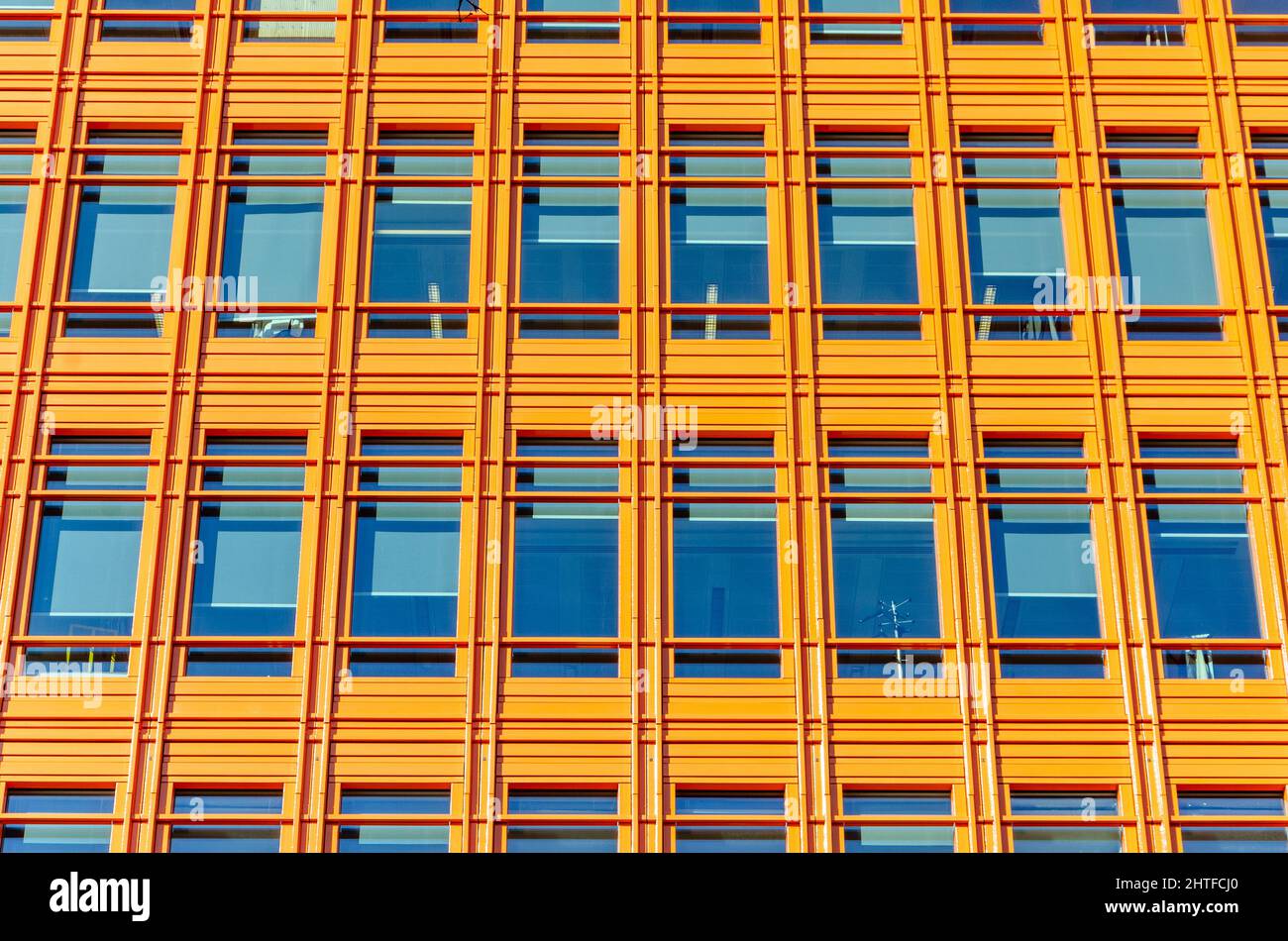 Nahaufnahme der Fenster in einem modernen, modernen Bürogebäude. Die Fenster sind in regelmäßigen, einheitlichen geometrischen Zeilen und Spalten angeordnet Stockfoto