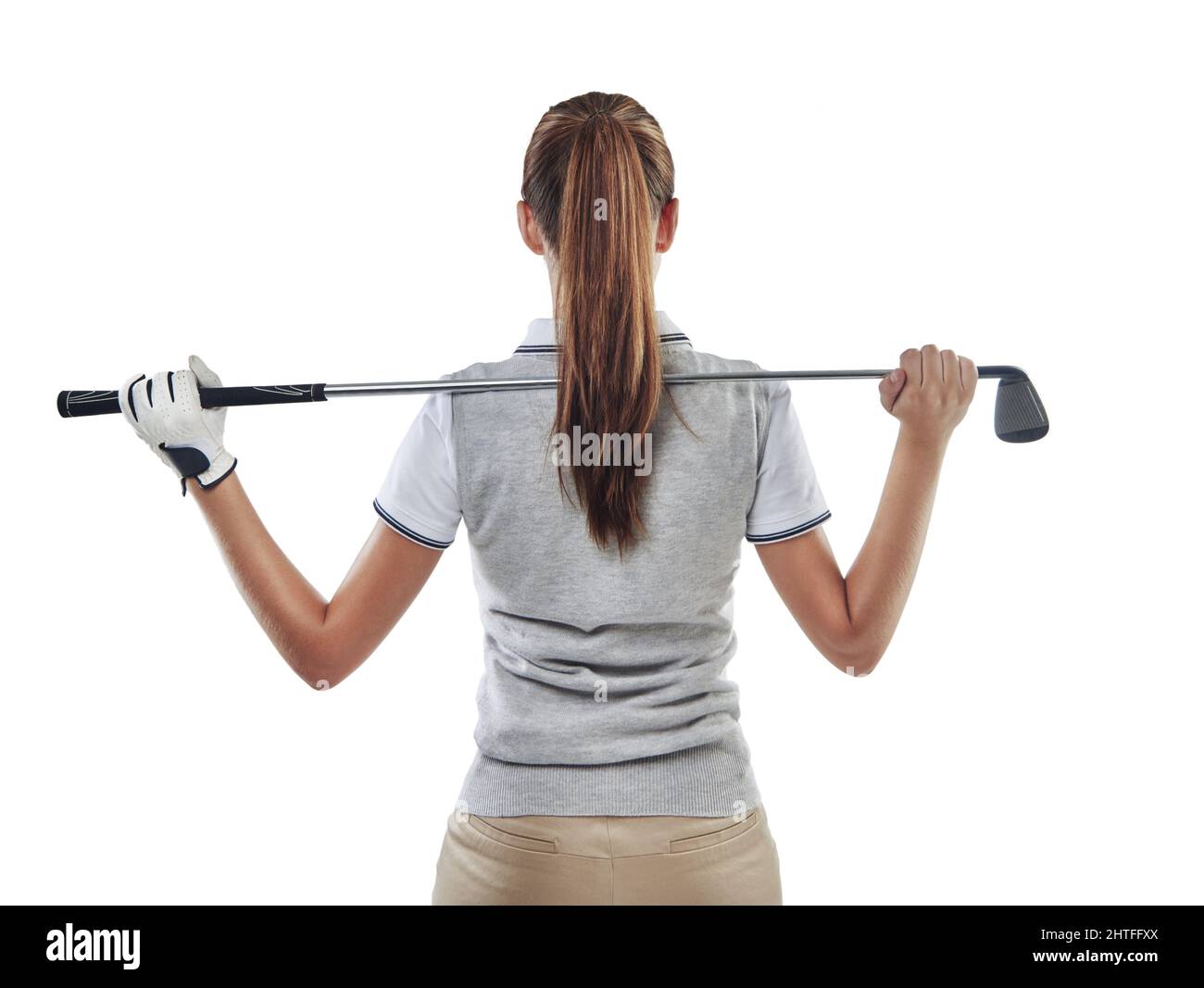 In Führung ihres Clubs. Studioaufnahme einer jungen Golferin, die einen Golfschläger hinter ihrem Rücken in Weiß gehalten hat. Stockfoto