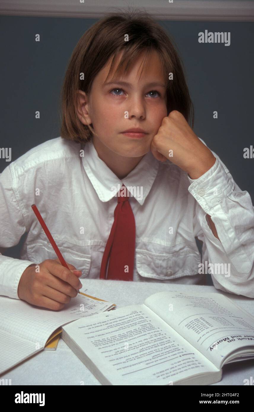 Uniformierte junge Mädchen kämpfen um mathematische Hausaufgaben Stockfoto