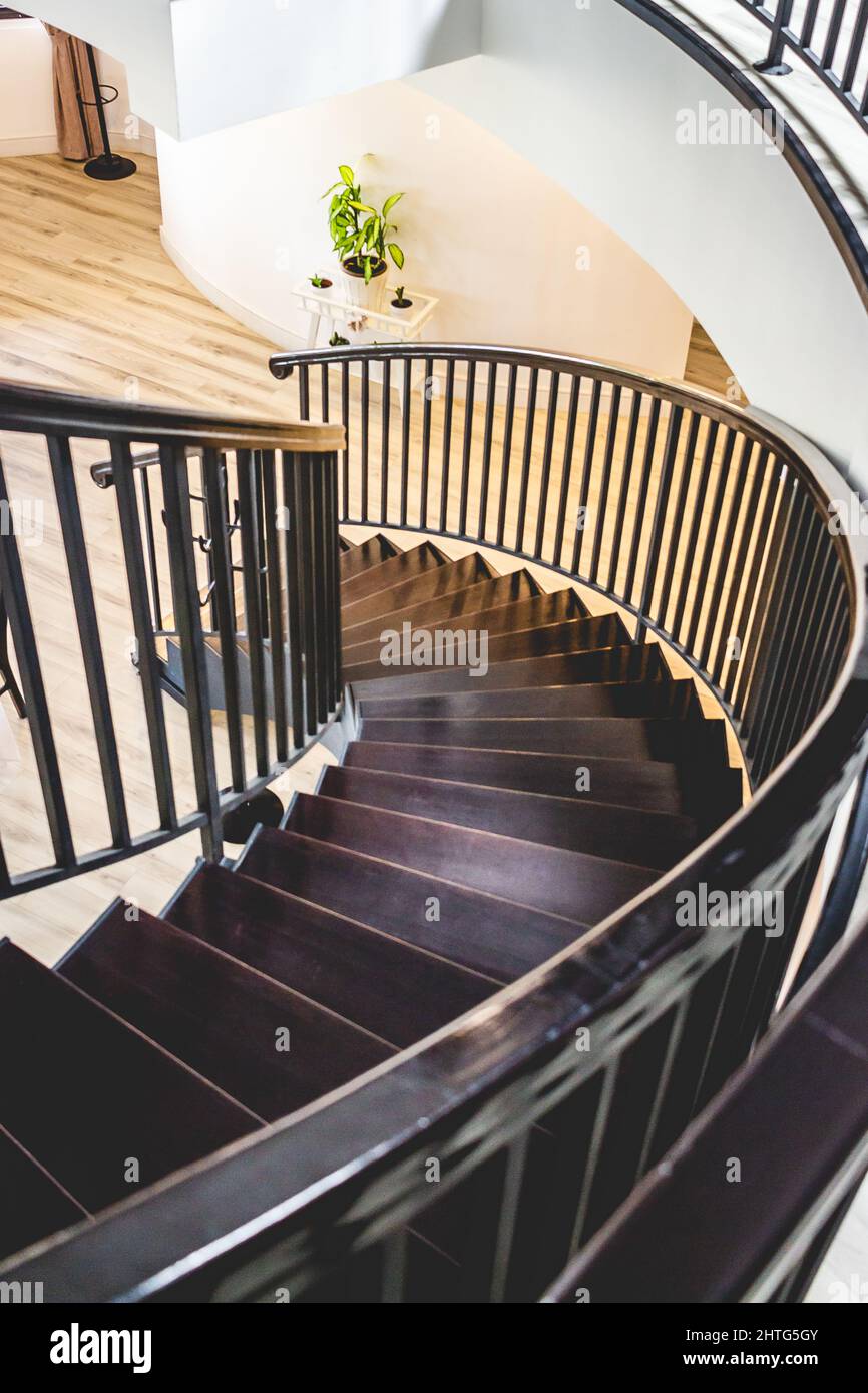 Schwarze Holztreppe mit schwarzen Geländern in einem zweistöckigen Haus Stockfoto