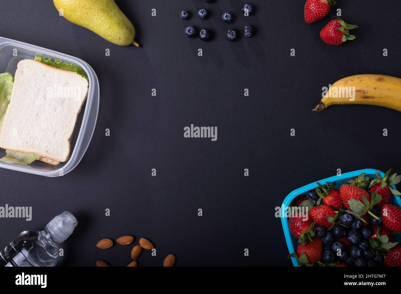 Overhead-Ansicht von gesunden Lebensmitteln mit Lunchbox auf schwarzem Hintergrund, Platz zum Kopieren Stockfoto