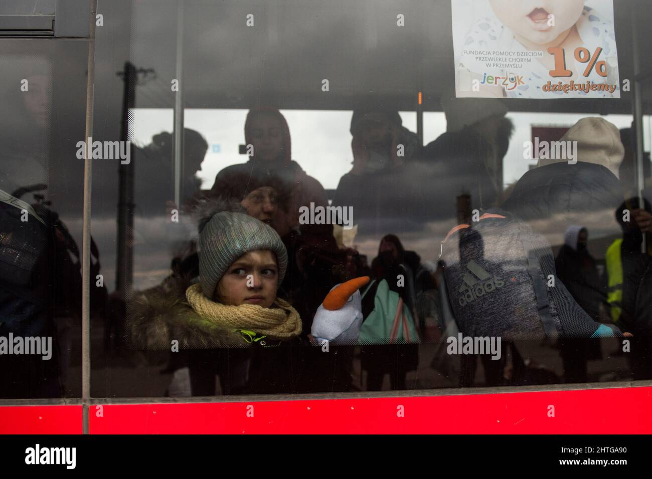 Medyka, Polen. 28.. Februar 2022. Ein kleines Mädchen, das durch das Fenster eines Busses gesehen wurde, der gerade die polnische Grenze überquerte.Schätzungen zufolge sind bereits fast eine halbe Million Menschen aus der Ukraine nach Polen geflohen. Am fünften Tag der russischen Invasion überqueren Tausende von Asylbewerbern die Grenze in Medyka. Kredit: SOPA Images Limited/Alamy Live Nachrichten Stockfoto