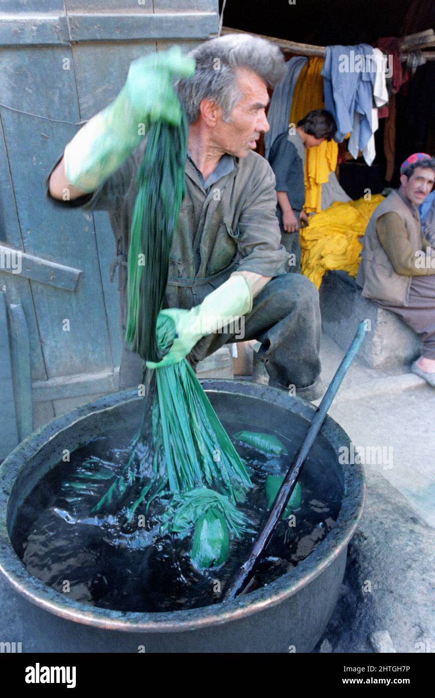 KABUL, AFGHANISTAN. 27.. Februar 1989. Ein afghanischer Mann färbt Burkas, die traditionelle afghanische Ganzkörperhülle, die von einer traditionellen Frau getragen wird, in einem Geschäft auf dem Hauptmarkt am 27. Februar 1989 in Kabul, Afghanistan. Stockfoto