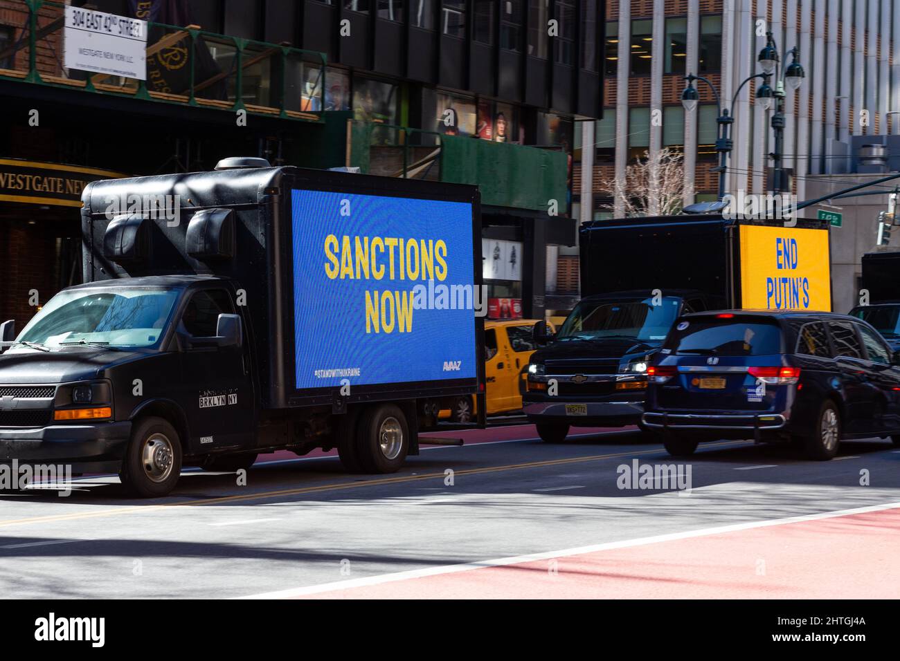 New York, NY, USA. 28.. Februar 2022. Beleuchtete Schilder mit Anti-Kriegs-Lastwagen, die abwechselnd russische und englische Texte tragen, fahren um den Block herum, um vor Demonstranten zu fahren, die den Vereinten Nationen gegenüber auf der First Avenue gegenüberstehen. Diese, die die 42D Street hinunter fahren und kurz vor der Abbiegung in die First Avenue stehen, lauten „Sanctions Now“ und „End Putins war“. Quelle: Ed Lefkowicz/Alamy Live News Stockfoto