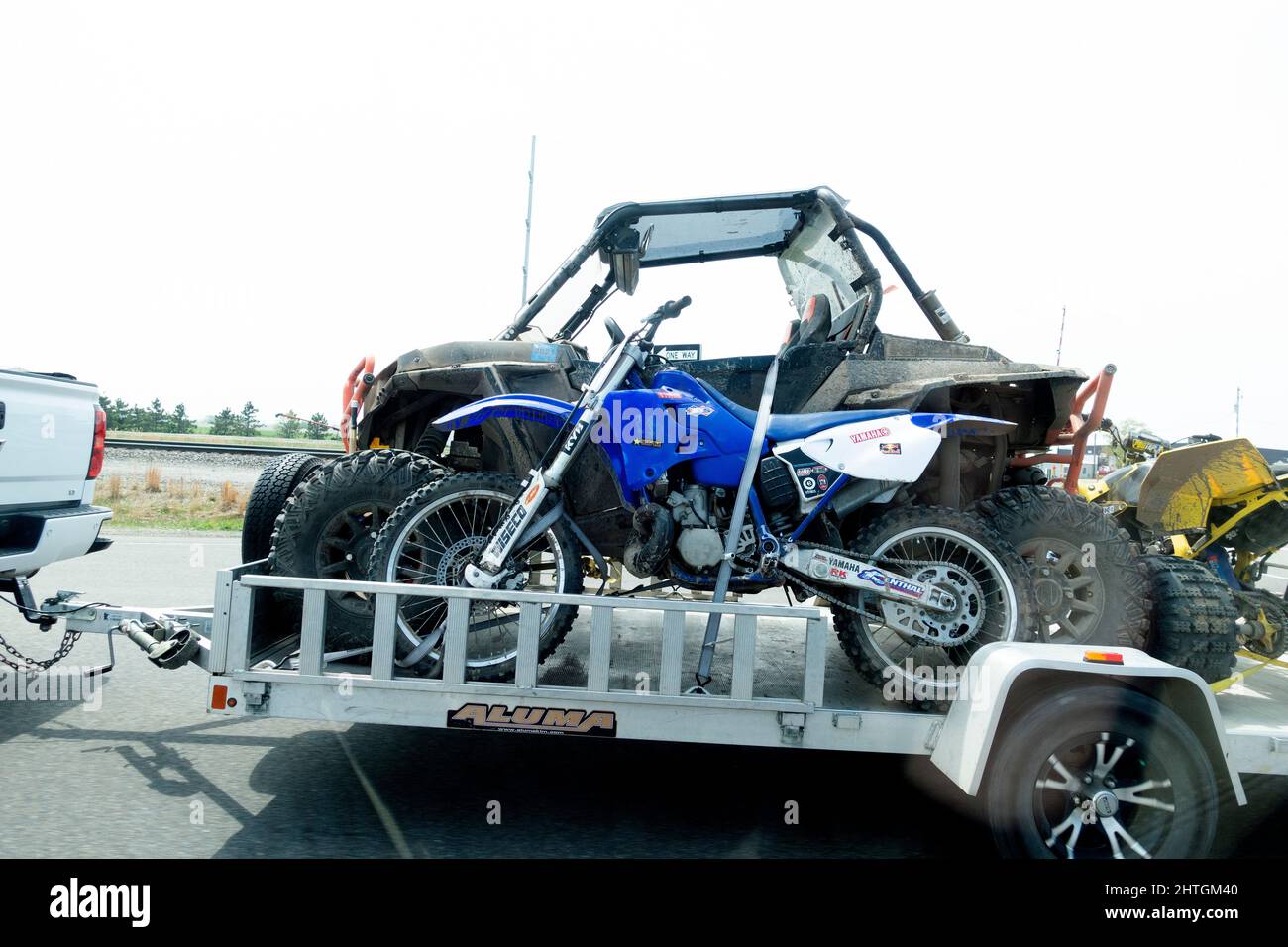Geländewagen mit vier Rädern und einem Yamaha Wiseco KYB Trailbike, der auf einem Anhänger zu einem unterhaltsamen Ziel transportiert wird. Nisswa Minnesota, USA Stockfoto