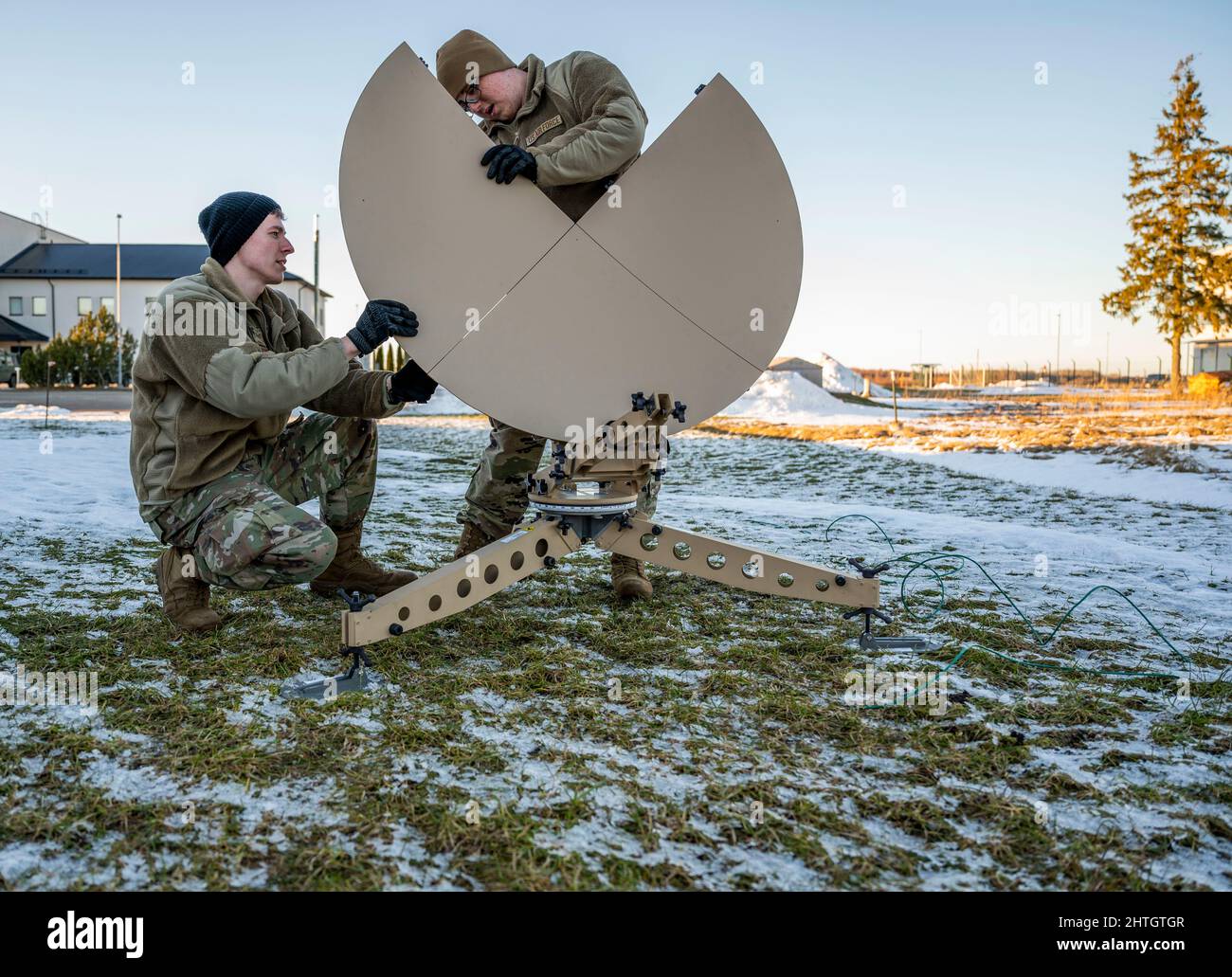 Harjumaa, Estland. 26. Februar 2022. Techniker der US Air Force für Cyber-Operationen, SSgt. Jordon Rodriguez, links, und Hochfrequenztechniker, SRA Nathanael Clark, montieren eine tragbare Satellitenschüssel auf dem Luftwaffenstützpunkt Amari, 26. Februar 2022 im estnischen Harjumaa sind NATO-Truppen eingetroffen, um Estland nach der russischen Invasion in die Ukraine zu unterstützen. Kredit: SSGT. Megan M. Beatty/U.S. Army/Alamy Live News Stockfoto