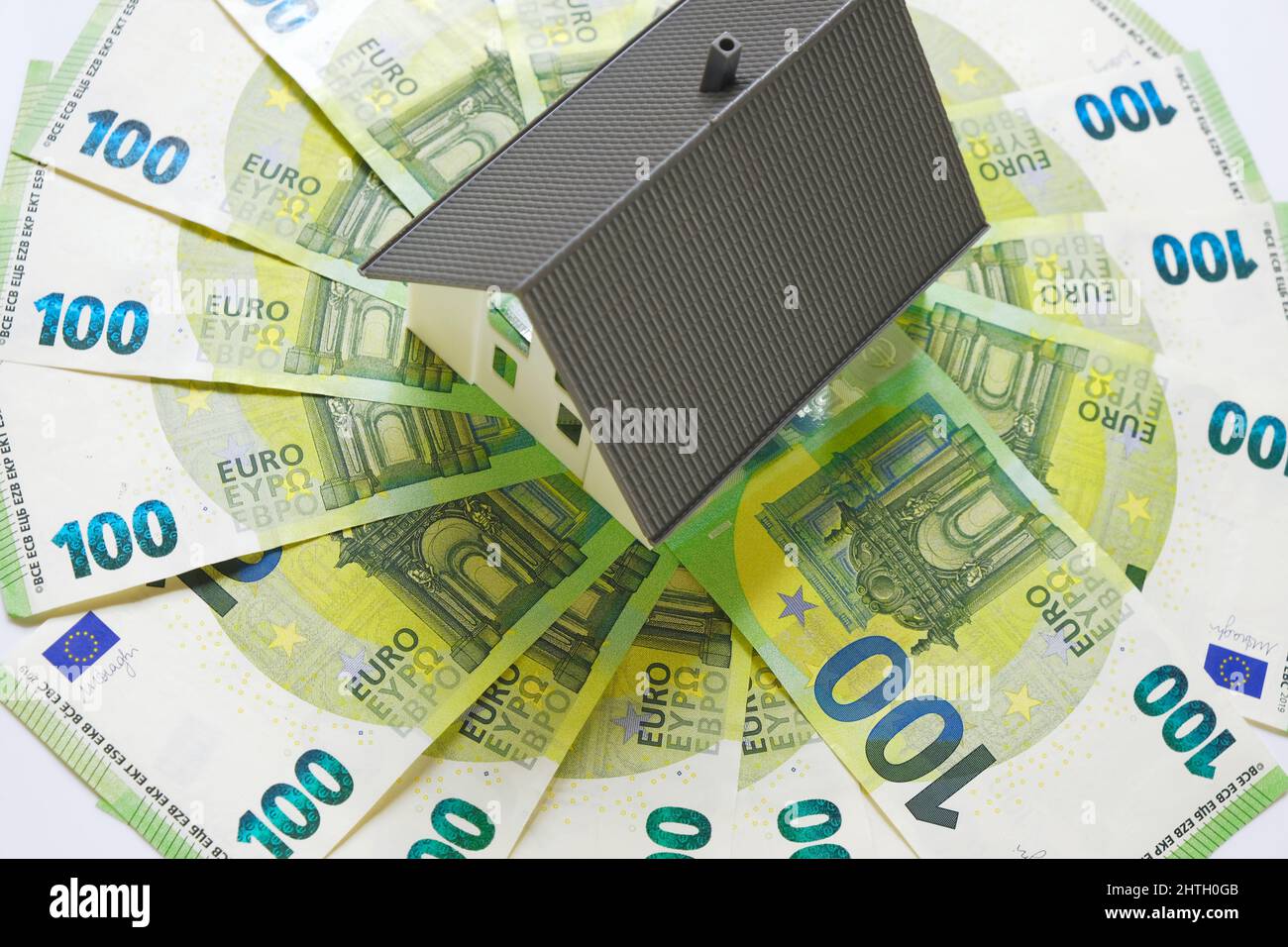 Kauf und Bau eines Hauses.Home Wartungskosten. Scheinhaus mit Dach auf Euro-Banknoten Hintergrund. Immobilienkredit.Haus und Geld Stockfoto