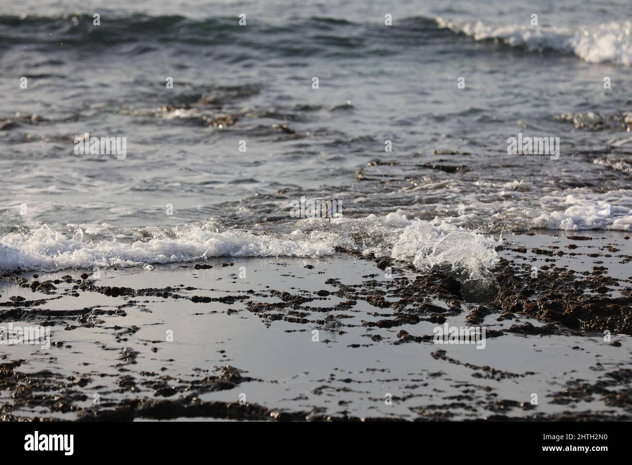 Verschwommener abstrakter natürlicher Hintergrund des Meerwassers mit Wellen und Schaum. Bewegungsunschärfe. Natur. Stockfoto