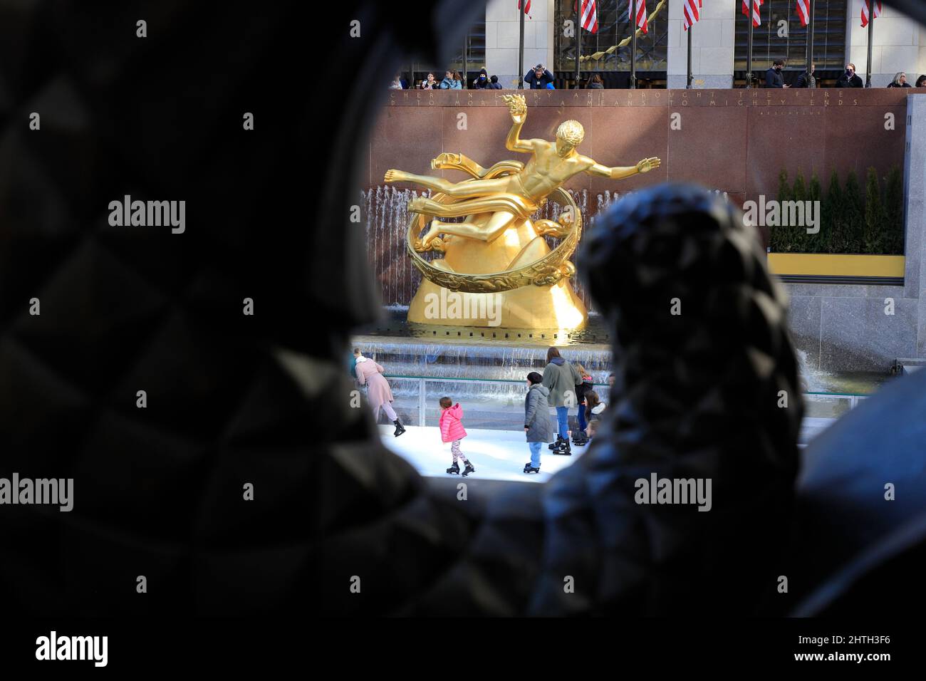 Menschen, die in der Rink am Rockefeller Center mit vergoldeter goldener Statue des Prometheus im Hintergrund Schlittschuhlaufen.Midtown Manhattan.New York City.NY.USA Stockfoto