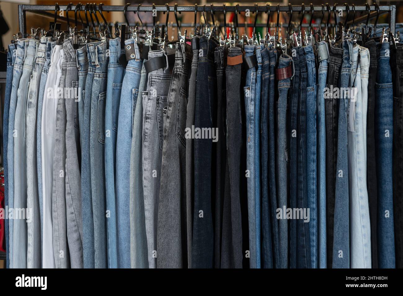 Nahaufnahme, blaue Jeans auf einem Kleiderbügel in einem Bekleidungsgeschäft, Verkauf von Markenartikeln, Denim-Produktionsabteilung. Kleidung Hintergrund Stockfoto