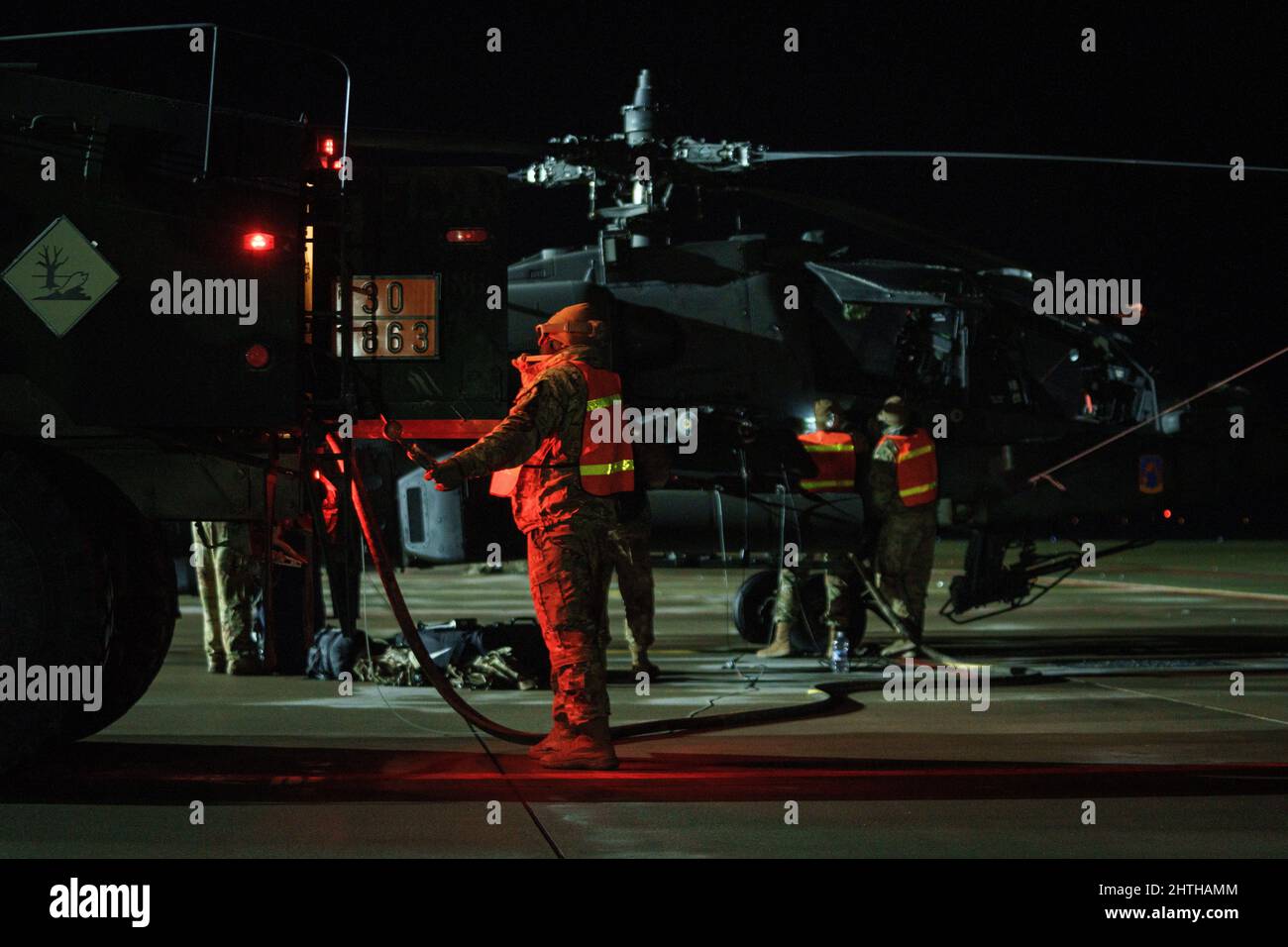 Soldaten der US-Armee wurden 1-3. Angriffsbataillon, 12. Combat Aviation Brigade, eingesetzt, um AH-64D Apache Longbow-Hubschrauber auf dem Militärflugplatz Lielvarde, Lettland, 24. Februar 2022, aufzutanken. Elemente des CAB 12 verließen Deutschland nach Litauen und Lettland, um mit NATO-Verbündeten zur Unterstützung von Sabre Strike 22 zu trainieren. 12 CAB trainiert und bleibt eine ständige und glaubwürdige Luftwaffe der US-Armee zur Unterstützung von Verbündeten und Partnern sowie der Stabilität und Sicherheit Europas. (USA Foto der Armee von Staff Sgt. Thomas Mort) Stockfoto