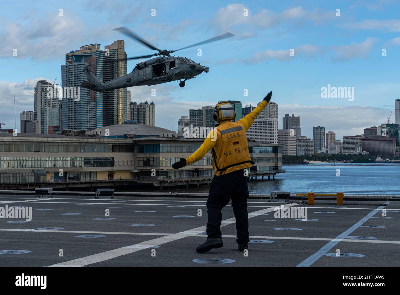 220211-N-FA490-3026 MANILA, Philippinen (Feb 11, 2022) – Boatswains Mate 2. Klasse Patrick Hix, aus Independence, Missouri, der dem Littoral Combat Ship USS Jackson (LCS 6) in Independence-Variante zugewiesen wurde, leitet einen MH-60s Hubschrauber, der den „Wildcards“ des Helicopter Sea Combat (HSC) Squadron 23 zugewiesen wurde, um auf dem Flugdeck von Jackson zu landen. Jackson und HSC-23, die an Destroyer Squadron (DESRON) 7 angeschlossen sind, befinden sich im Rotationseinsatz im Einsatzgebiet der US-7.-Flotte, um die Sicherheit und Stabilität in der Region zu unterstützen und mit alliierten und Partnermarines zusammenzuarbeiten, um maritime Seestreitkräfte bereitzustellen Stockfoto