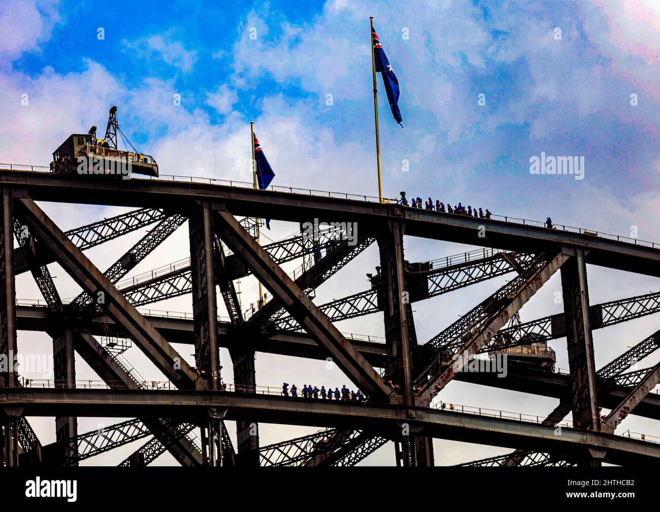 Zwei Gruppen von Touristen auf verschiedenen Ebenen genießen den Aufstieg auf Sydneys denkmalgeschützter Hafenbrücke, die am 19. März 1932 für den Verkehr geöffnet wurde Stockfoto