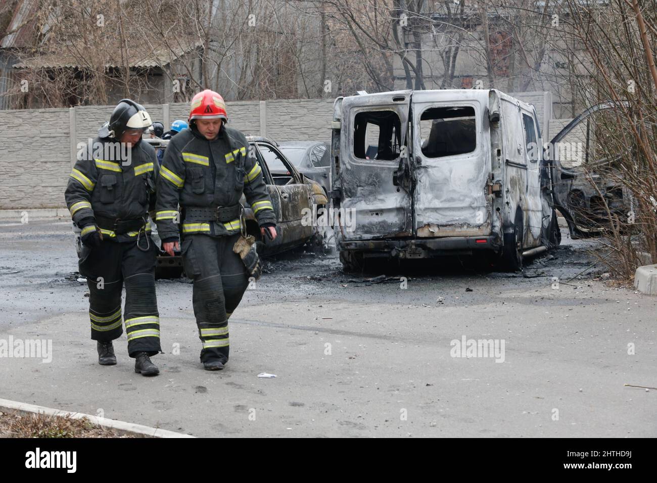 Donezk. 28.. Februar 2022. Feuerwehrleute laufen in Donezk am 28. Februar 2022 an verbrannten Autos vorbei. Kredit: Victor/Xinhua/Alamy Live Nachrichten Stockfoto