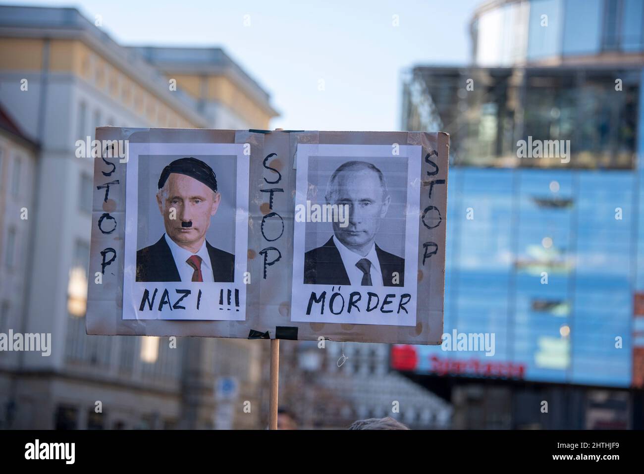 Magdeburg, Sachsen-Anhalt, Deutschland, Demonstranten halten ein Transparent mit der Aufschrift „Nazi, Mord“. Darüber sind Fotos zu sehen, die Putin als den neuen Hitler zeigen. Stockfoto