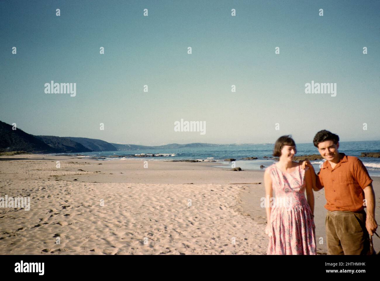 Mann und Frau stehen 1956 am Sandstrand in Lorne, Victoria, Australien Stockfoto