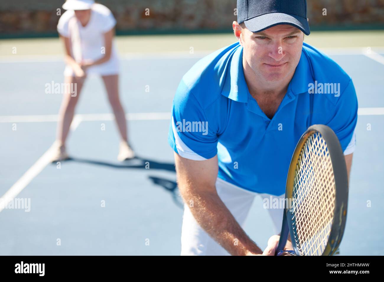 Hes hat sein Spiel Gesicht auf. Ein gemischtes Doppelteam steht bereit, einen Aufschlag zu erhalten - Tennis. Stockfoto