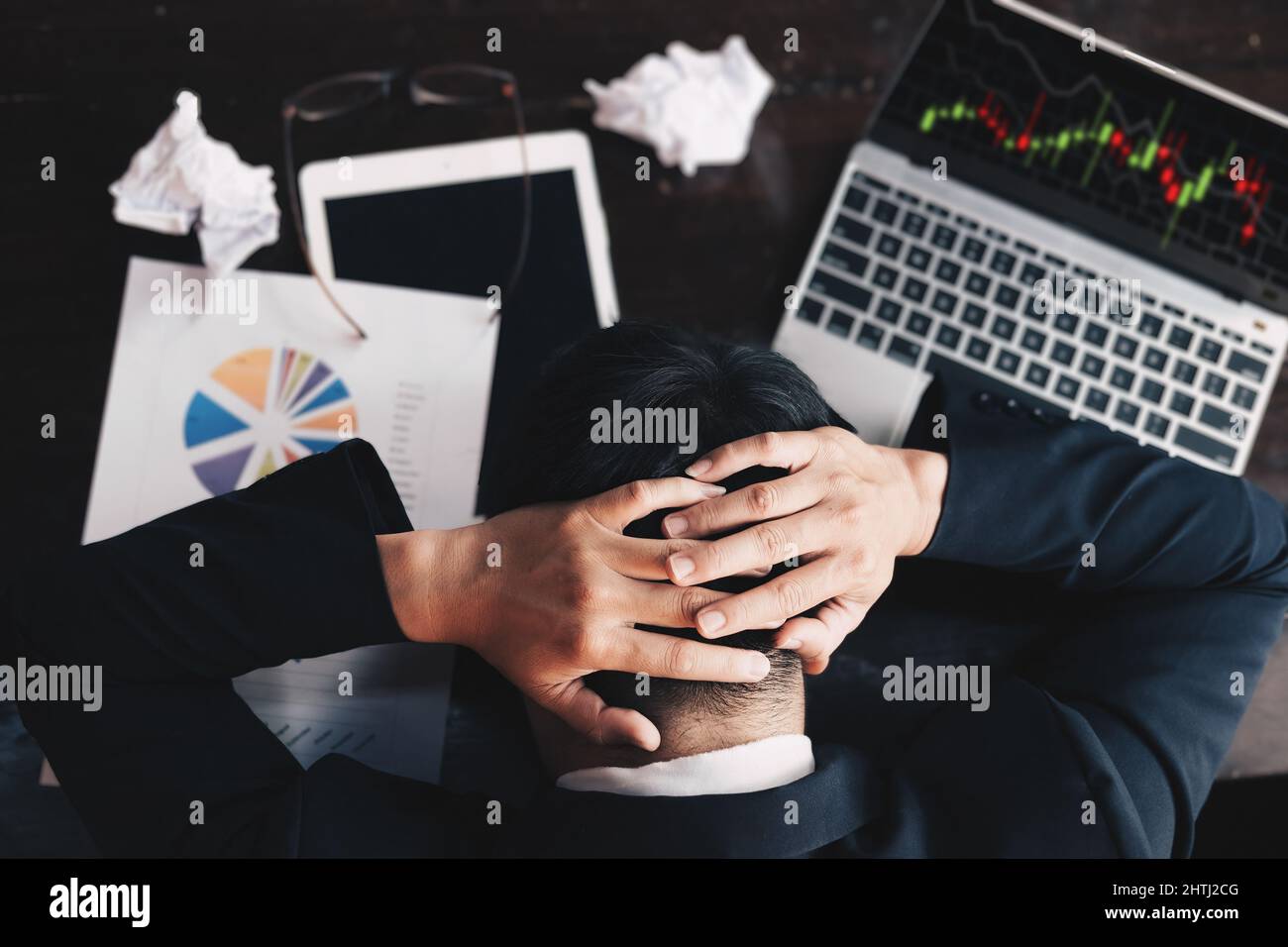 Das Aktienmarktkonzept, der Geschäftsmann, der sich die Aktienmarktgrafik auf dem Computerbildschirm ansieht, zeigt Enttäuschung, nachdem er Aktien gekauft hat, aber nicht profitiert hat Stockfoto