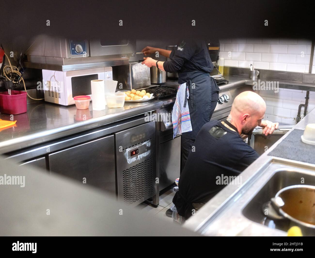 Zwei Personen, die in der Küche eines Restaurants arbeiten Stockfoto