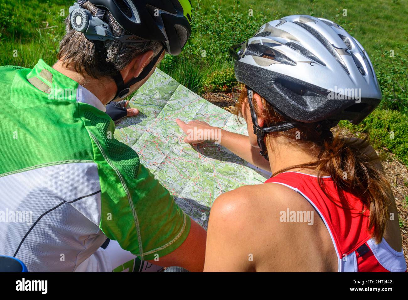 Mountainbiker orientieren sich auf einer Karte Stockfoto