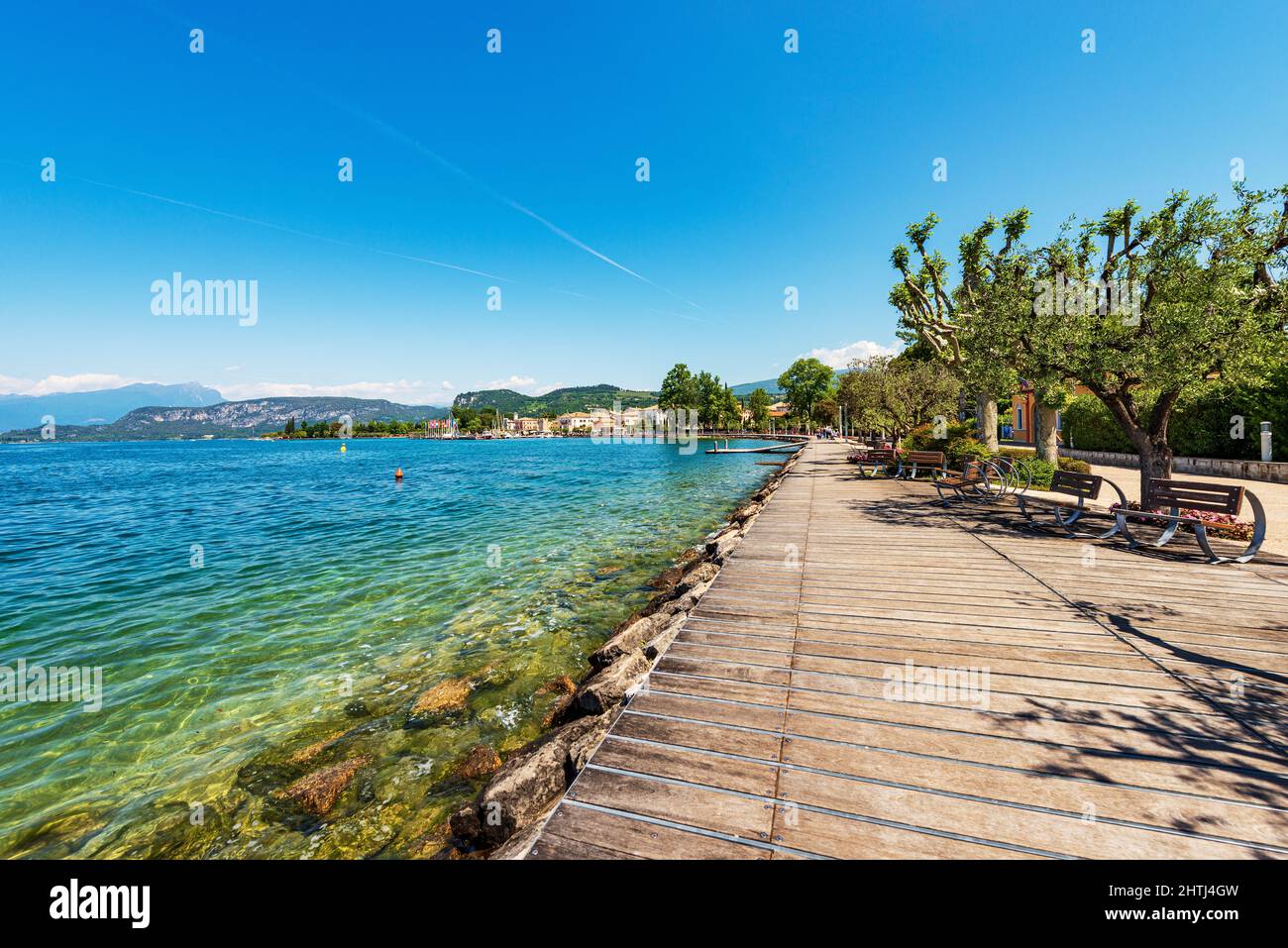 Promenade am Gardasee mit Holzboden und Bänken. Kleines Dorf Bardolino, Ferienort in der Provinz Verona, Venetien, Italien. Stockfoto