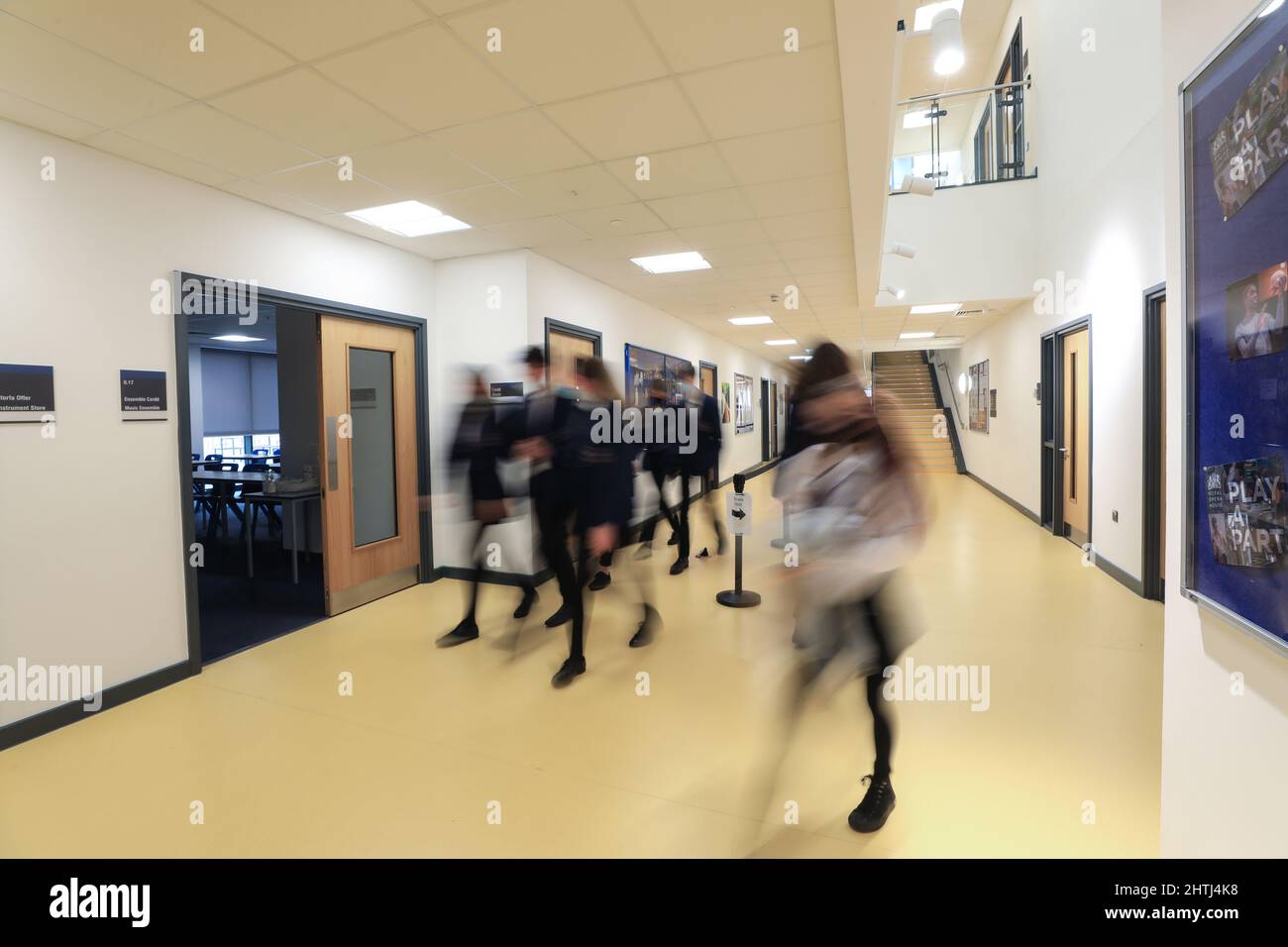 Kinder, die zwischen Klassenzimmern, Schulfluren und Treppen laufen. Langsame Belichtung, um Identität zu verbergen Stockfoto