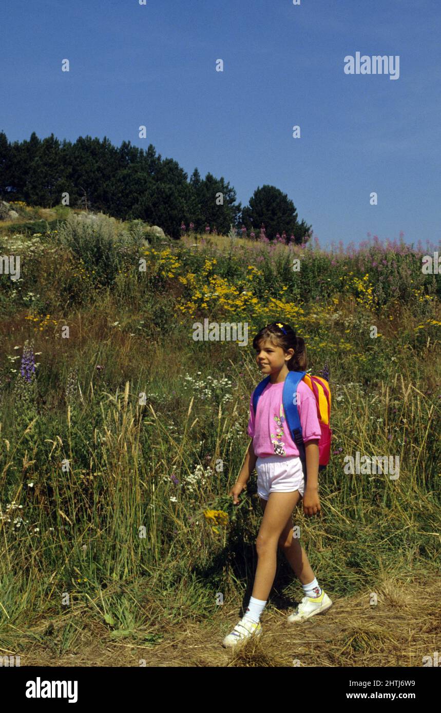 Kleines Mädchen mit Rucksack zu Fuß Berg Stockfoto