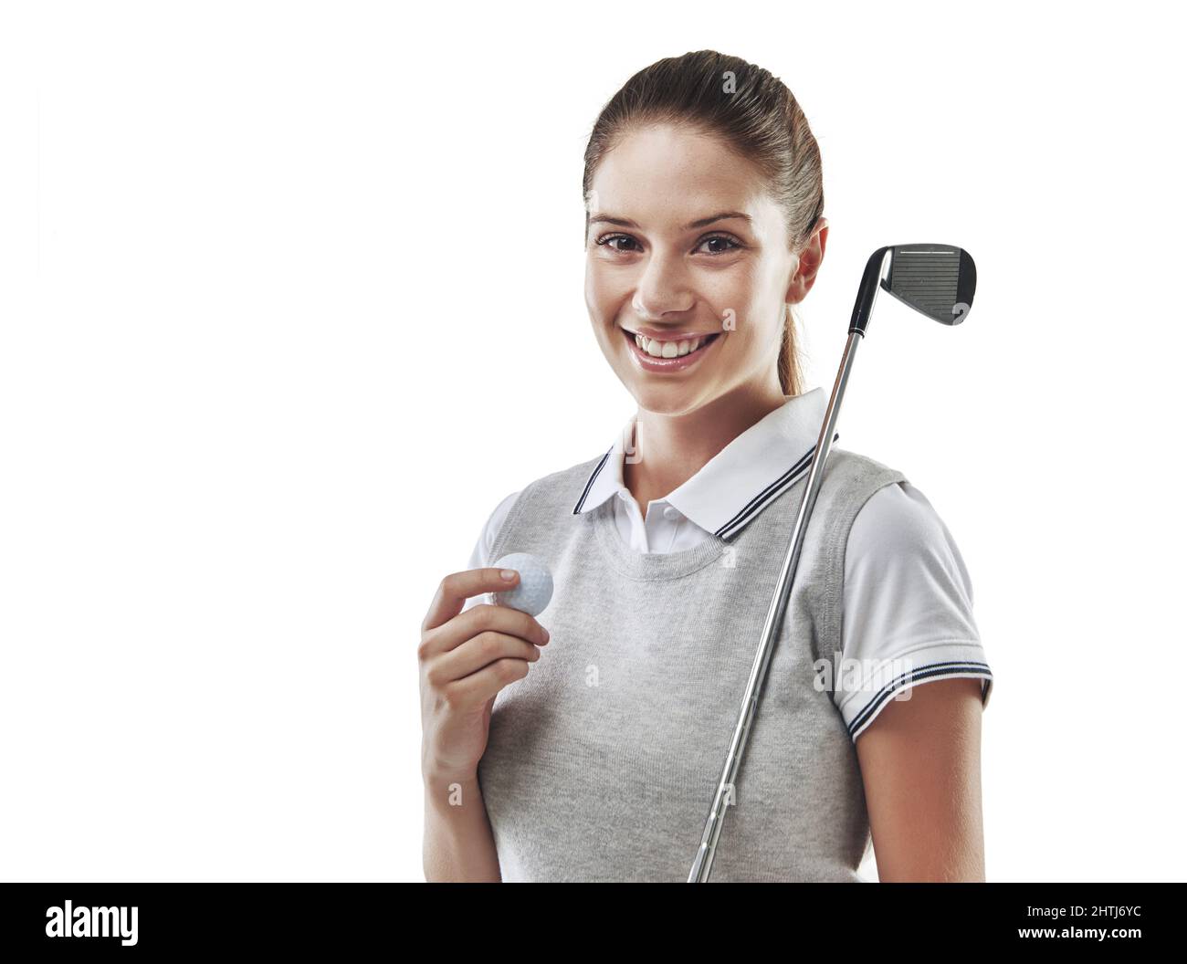 Was für eine Partie Golf. Studioaufnahme eines jungen Golfers, der einen Golfball und einen Eisenklub in Weiß hält. Stockfoto