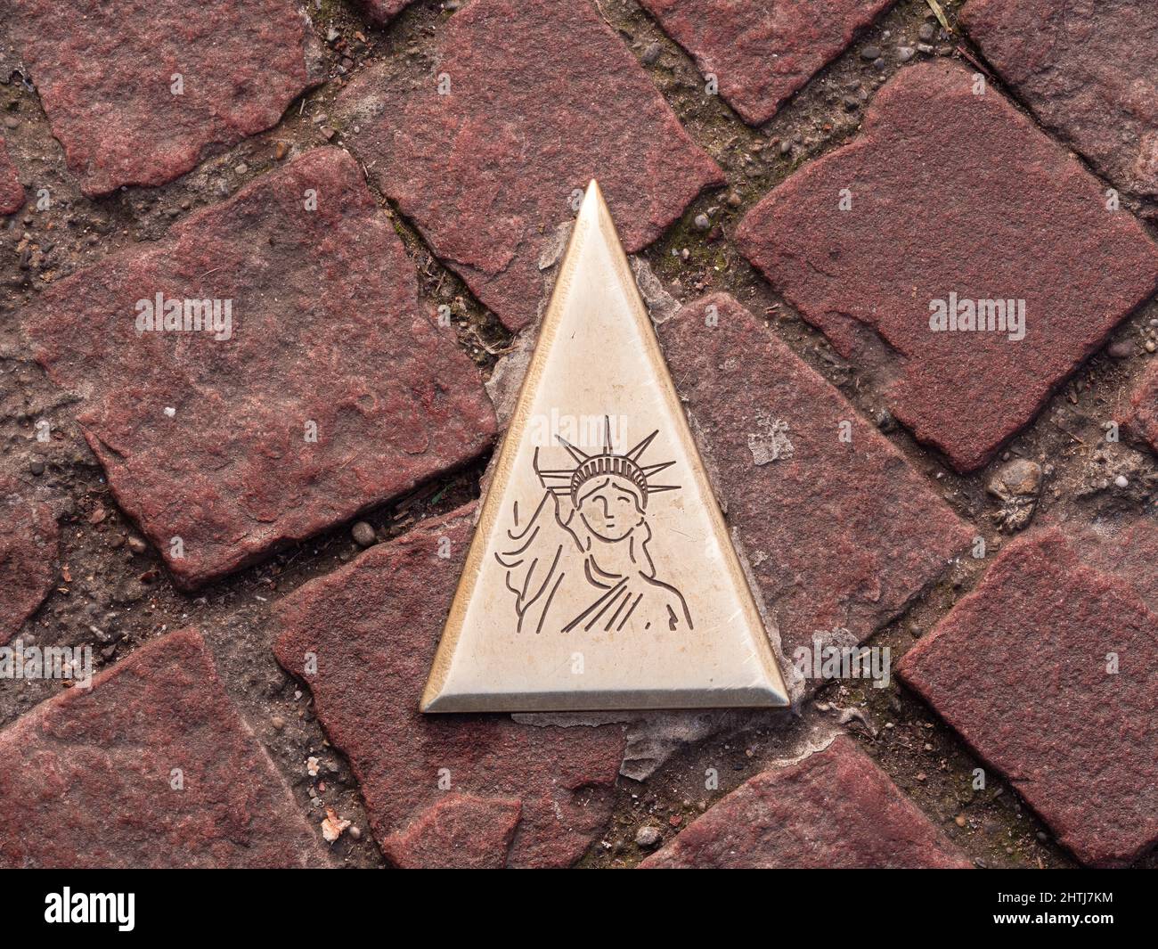 Colmar, Frankreich - 13. Dezember 2021: Richtungsschild auf dem Boden in Colmar, das in Richtung New York und Freiheitsstatue zeigt. Stockfoto