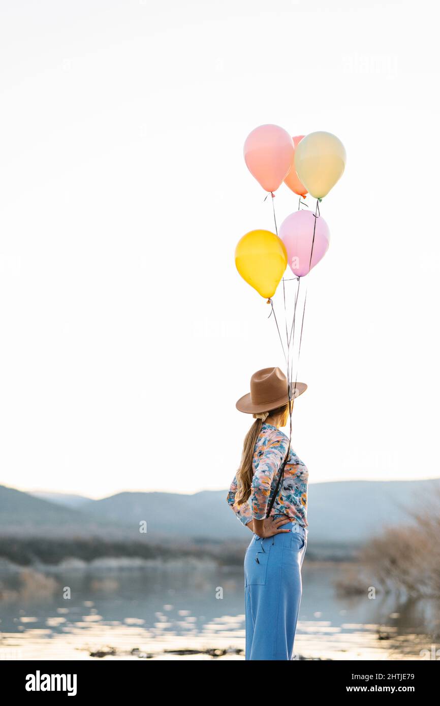 Seitenansicht eines nicht erkennbaren männlichen Touristen in warmer Oberbekleidung und Rucksack, der auf einer hölzernen Fußgängerbrücke steht und den atemberaubenden Blick auf Seljalandsfoss wate bewundert Stockfoto