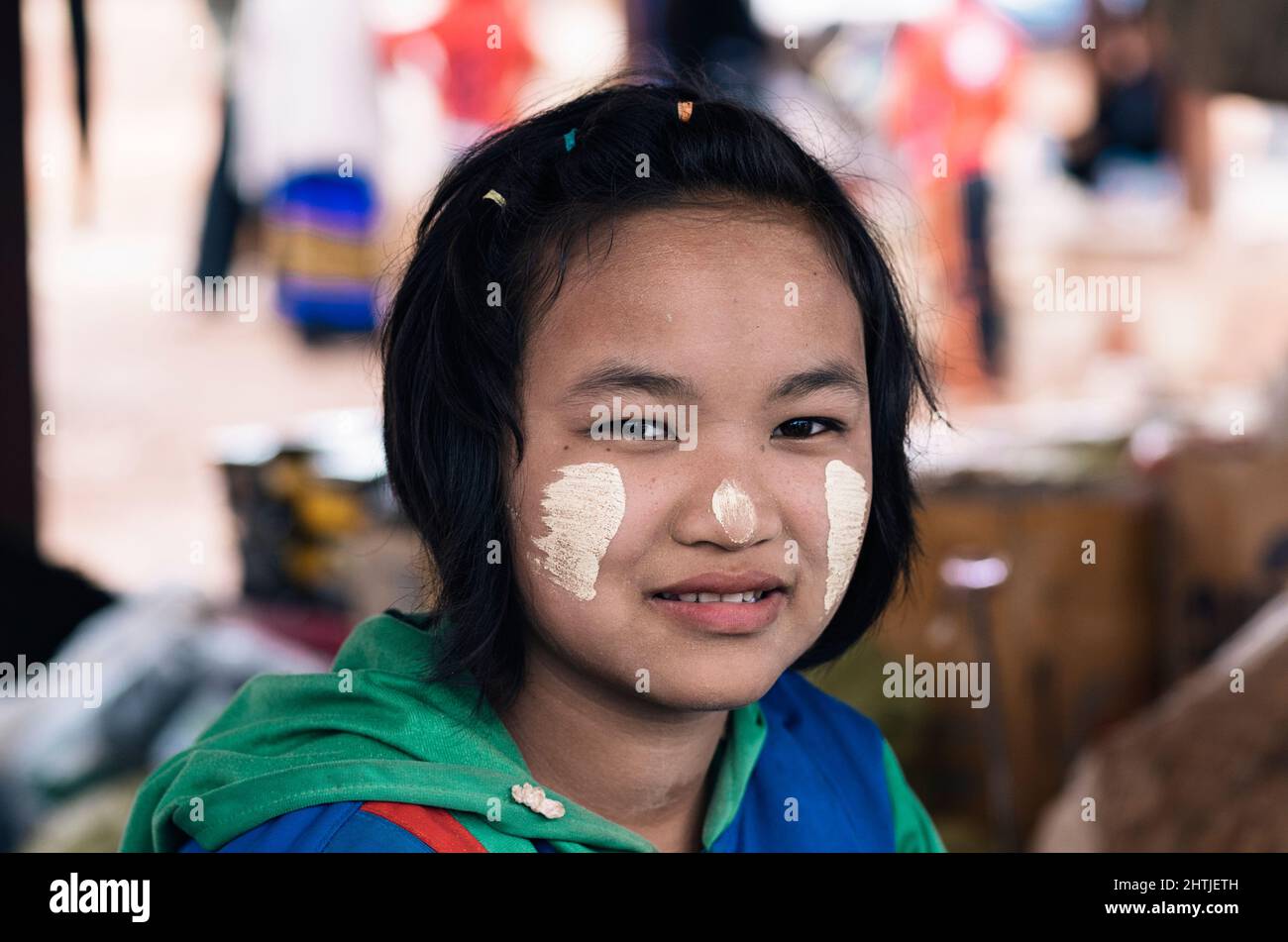 Kakku, Myanmar - 04.16.2017 - PaO Teenager-Mädchen mit weißer Tanaka-Kosmetikpaste auf dem lokalen Straßenbasar im Dorf und schaut in die Kamera Stockfoto