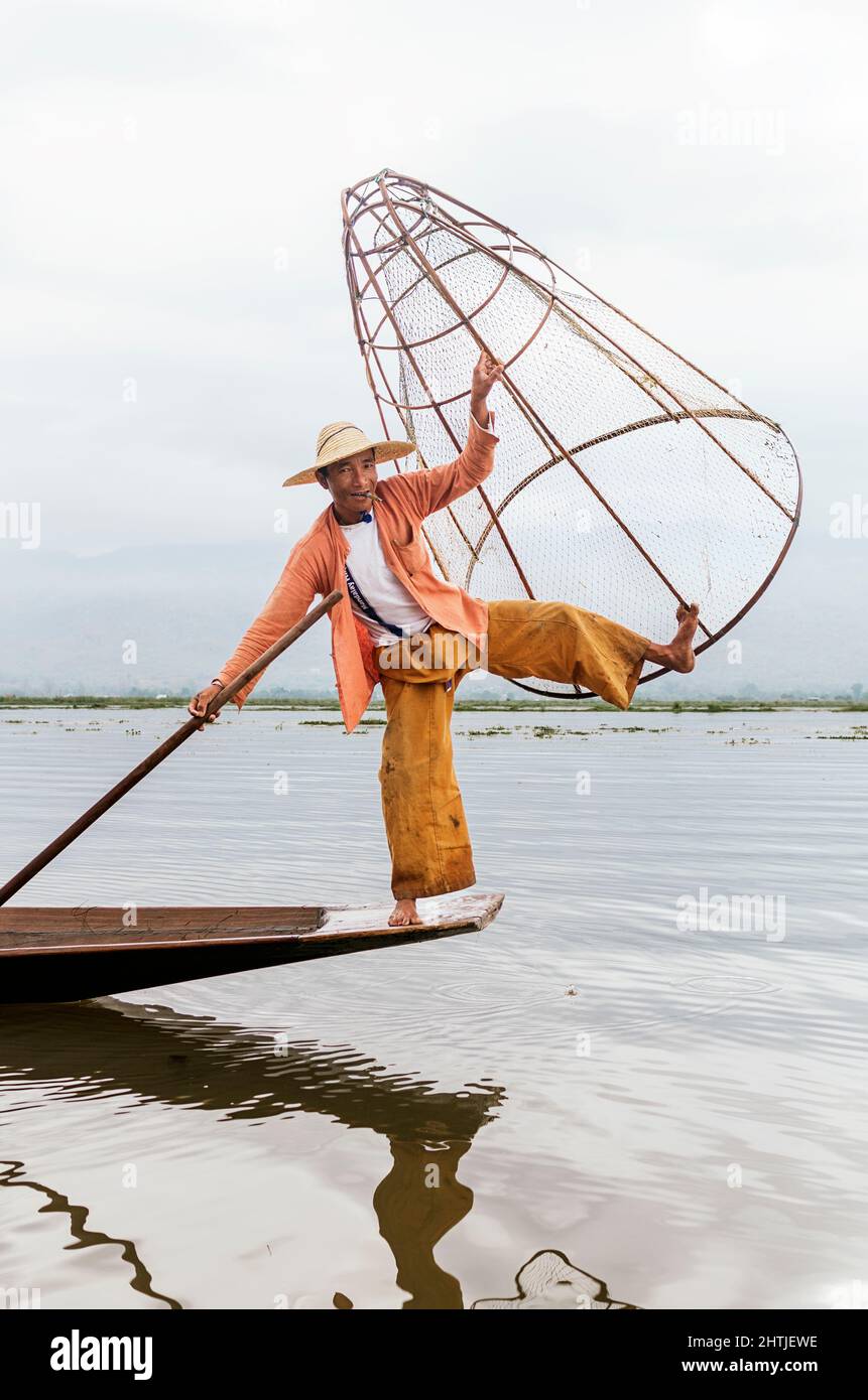 Shan Provinz, Myanmar - 04.18.2017: Ganzer Körper von asiatischen lokalen Fischern mit traditioneller Fangausrüstung, die auf dem Boot steht, während sie auf Inle Lak Fische fangen Stockfoto