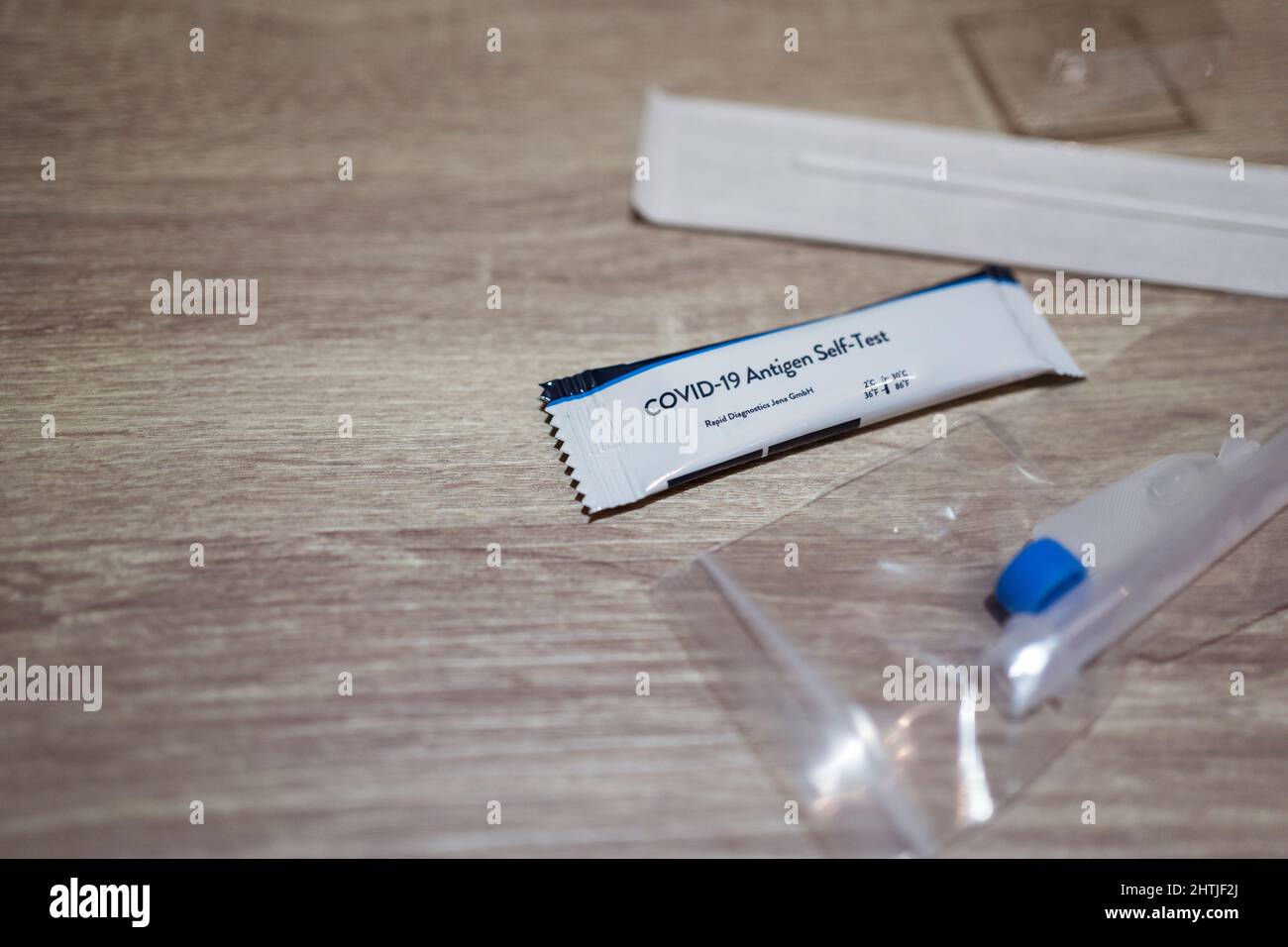 Von oben nach COVID 19-Antigenexpress-Test mit Nasenabstrich, der während einer Coronavirus-Pandemie auf dem Boden des hellen Raums platziert wurde Stockfoto