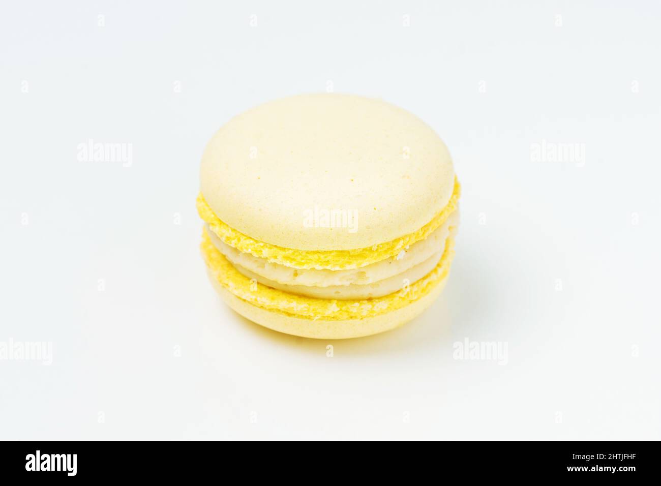 Von oben eine leckere runde Zitronengeschmack Makronen mit süßen gelben Füllung auf weißem Hintergrund in hellen Raum platziert Stockfoto