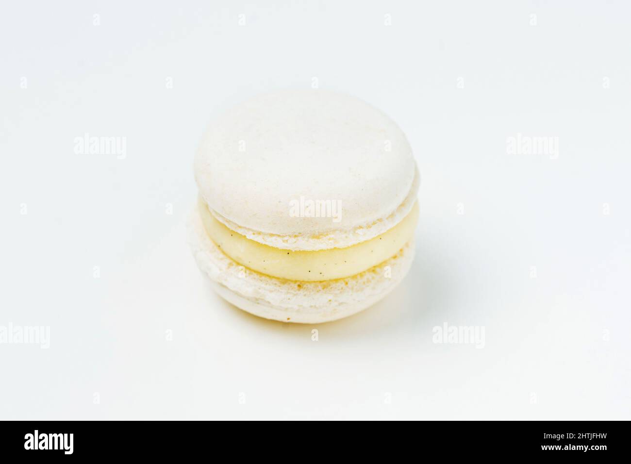 Von oben eine leckere runde Vanille aromatisierte Makronen mit süßgelben Füllung auf weißem Hintergrund in hellen Raum platziert Stockfoto
