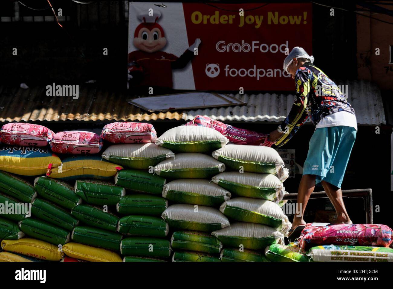 Manila, Philippinen. 1. März 2022. Ein Arbeiter entlädt Säcke Reis von einem Lastwagen entlang einer Straße in Quezon City, Philippinen. 1. März 2022. Die philippinische Regierung hat am 1. März die COVID-19-Beschränkungen in Metro Manila gelockert, was es Einrichtungen und öffentlichen Verkehrsmitteln ermöglicht, mit dem Sinken der Coronavirus-Fälle voll ausgelastet zu sein. (Bild: © Basilio Sepe/ZUMA Press Wire) Stockfoto