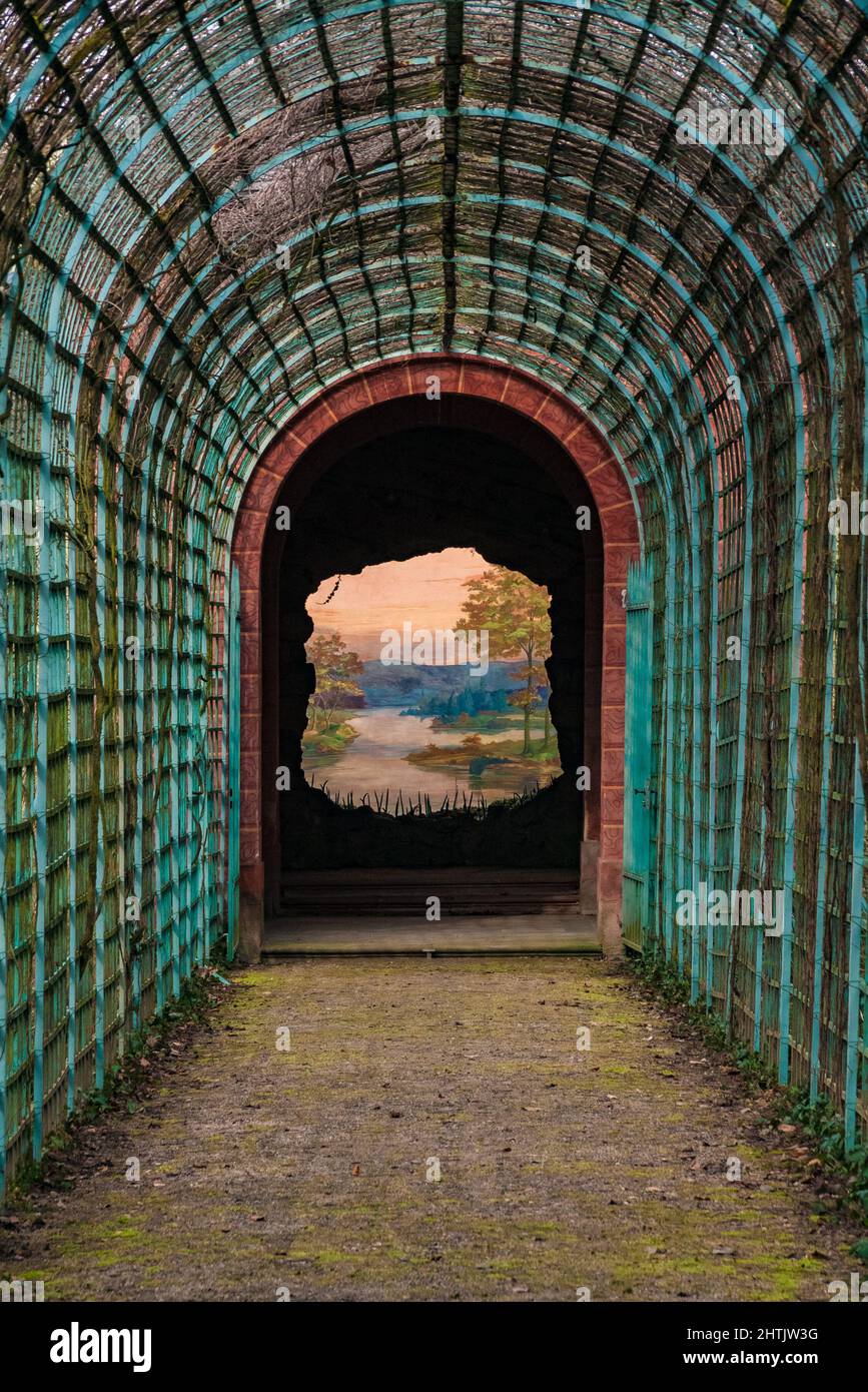 Eine Wand mit einem Gemälde namens „die Perspektive“ oder „das Ende der Welt“ im Badehausgarten von Schloss Schwetzingen in Deutschland. Eine Flusslandschaft... Stockfoto