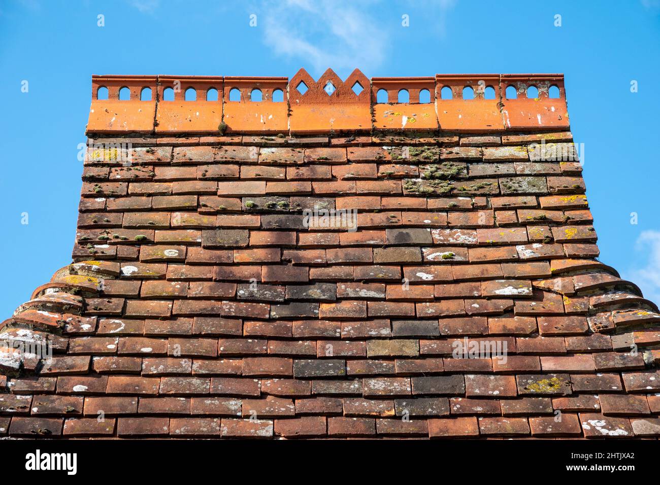 Kleines Dach mit perforierten Firstfliesen und abgerundeten Kanten aus rotem Ton an der East Hoathly Church Lych Gate, East Sussex Stockfoto