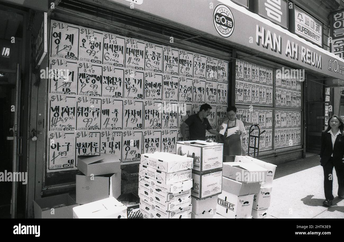 1980s, historisch, Außenansicht des ursprünglichen Han Ah Reum Asian Supermarket, Woodside, Queens, New York City, NY, USA, zeigt das Schaufenster vollständig mit Verkaufsaufklebern bedeckt und mit Kartons mit Lebensmitteln, die auf dem Bürgersteig draußen gestapelt sind, einschließlich Kartons mit Cantalopupes und Neuseeland Nashi. 1982 eröffnete Il Yeon Kwon das erste Han Ah Reum Lebensmittelgeschäft in Queens, NY, das später zu einer großen Kette asiatischer oder koreanisch-amerikanischer Supermärkte wurde, bekannt als H. Mart. Stockfoto