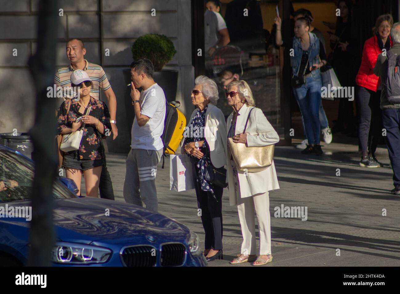 BARCELONA, SPANIEN - 4. OKTOBER 2019 zwei Damen warten an der Bordsteinkante vor den Geschäften Stockfoto