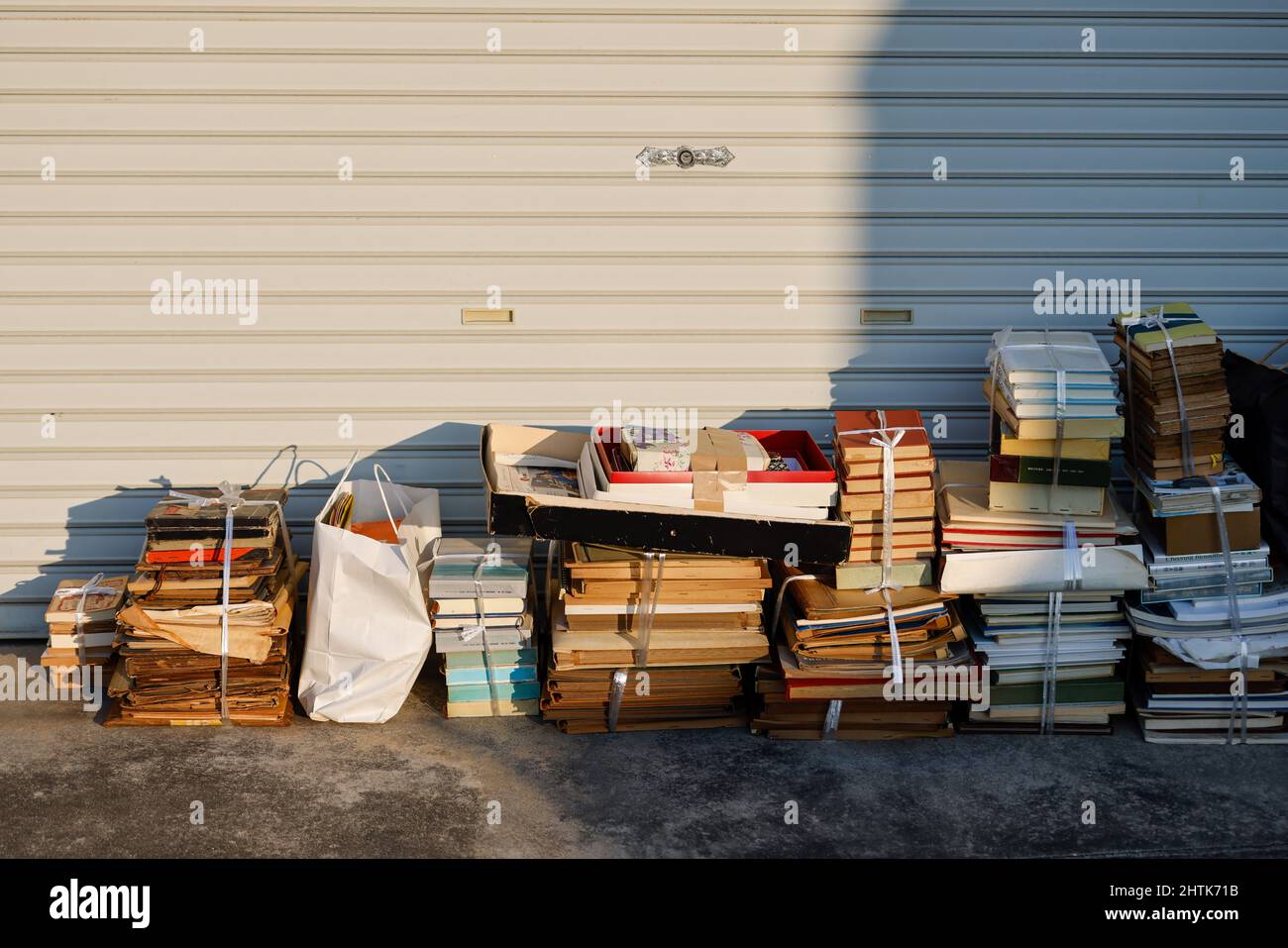 Stapel alter Bücher, die zum Recycling am Straßenrand gebündelt wurden Stockfoto