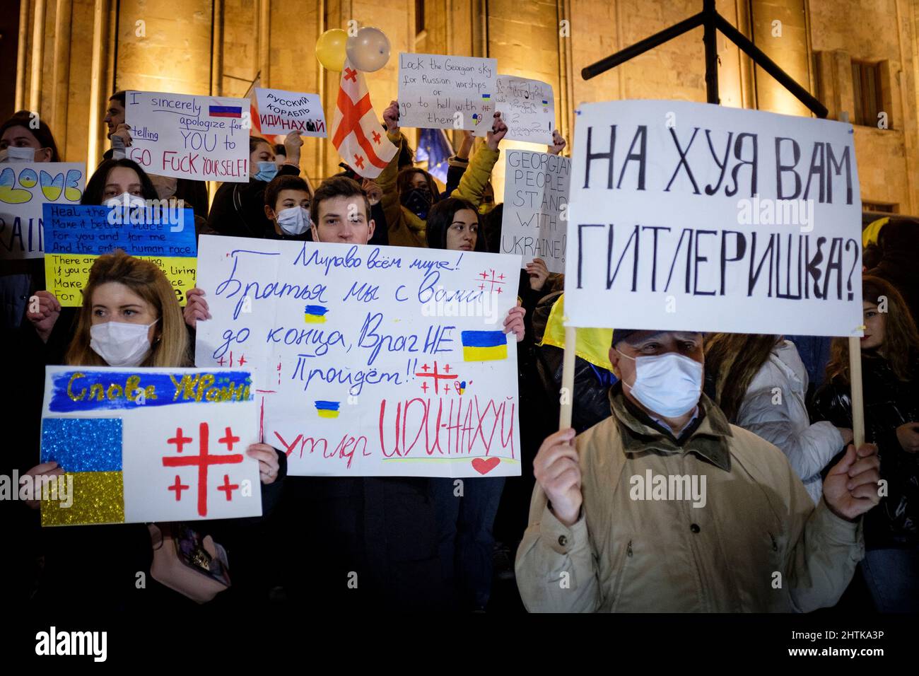 Georgien. 28.. Februar 2022. In Tiflis stehen Demonstranten am 5.. Tag der Proteste gegen die russische Invasion in der Ukraine vor dem Parlament Georgiens. Die Zeichen wünschen der Ukraine Ruhm und vergleichen Putin mit Hitler. (Bild: © Aurelien Foucault/ZUMA Press Wire) Stockfoto