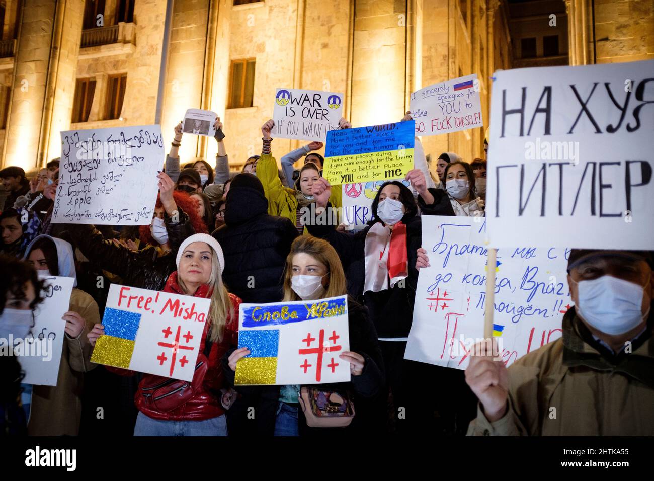 Georgien. 28.. Februar 2022. In Tiflis stehen Demonstranten am 5.. Tag der Proteste gegen die russische Invasion in der Ukraine vor dem Parlament Georgiens. Die Zeichen wünschen der Ukraine Ruhm und vergleichen Putin mit Hitler. (Bild: © Aurelien Foucault/ZUMA Press Wire) Stockfoto
