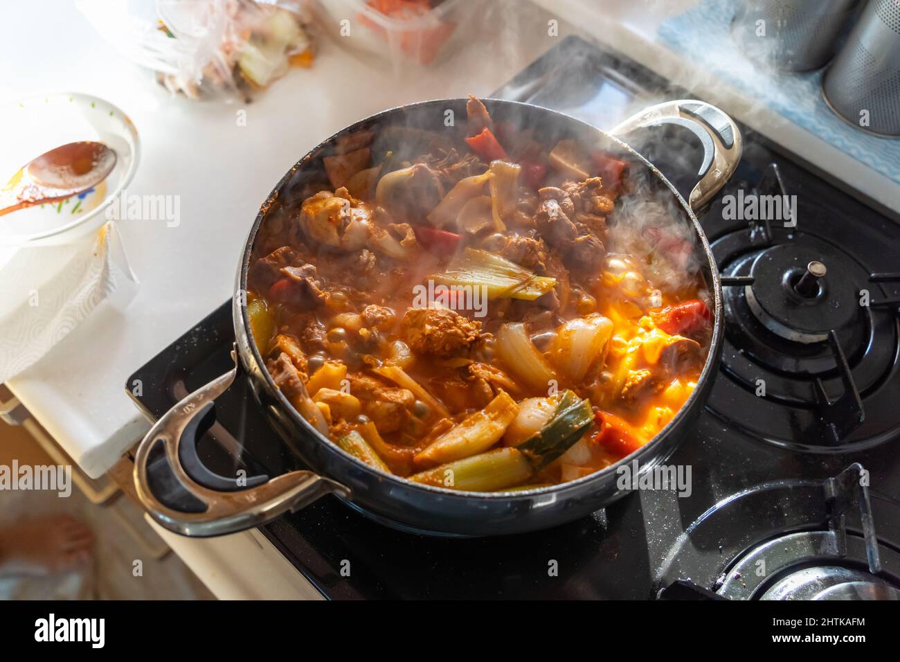 Geschmortes, würziges Huhn, das mit Dampf kocht. Stockfoto