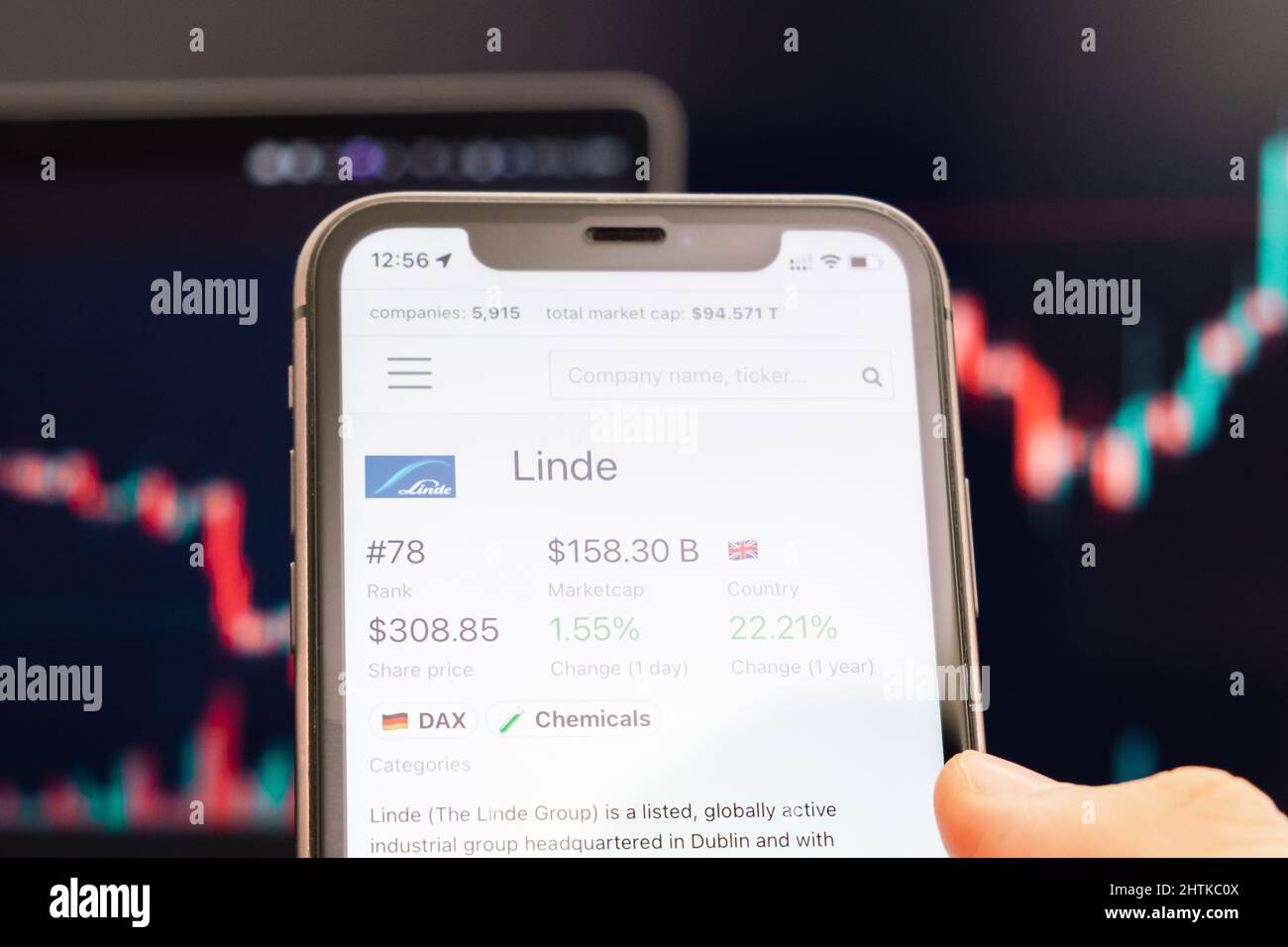 Linde-Aktienkurs auf dem Bildschirm des Mobiltelefons in mans Hand mit wechselnder Börse mit Trading Candlestick-Graph-Analyse, Februar 2022, San Francisco, USA Stockfoto